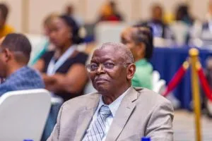 A participant in a suit seated among other conference attendees.